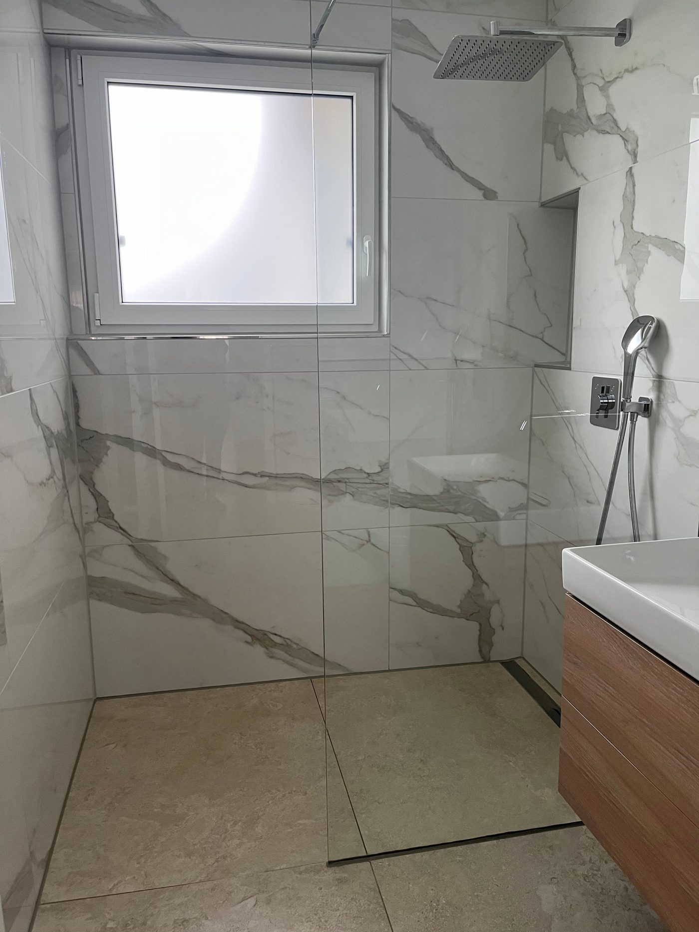 Begehbare Dusche mit Marmoroptik-Fliesen und Fenster – abgeschlossenes Projekt von Adel Fliesenlegerfachbetrieb